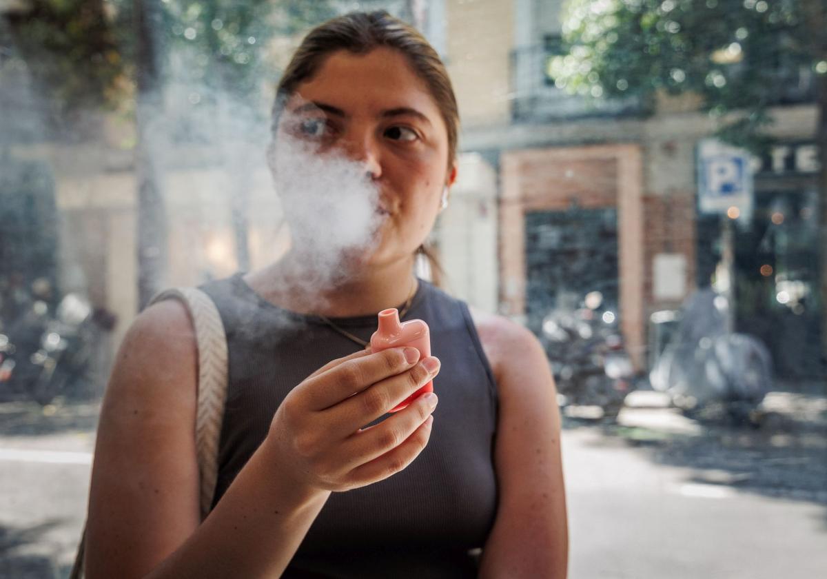Una joven fuma de un vape en una imagen de archivo