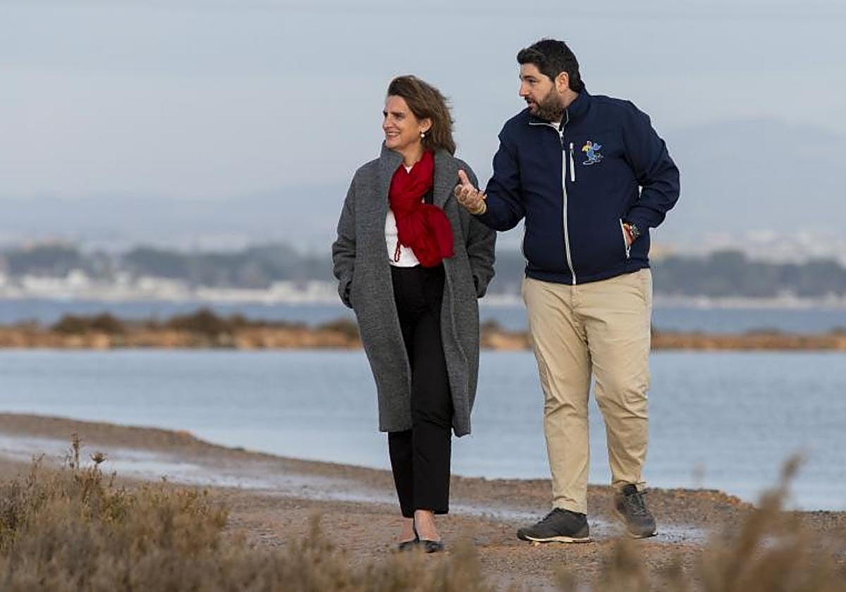 La exministra de transición ecológica, Teresa Ribera, y el presidente de la Comunidad de Murcia, Fernando López Miras, durante un paseo por el mar Menor