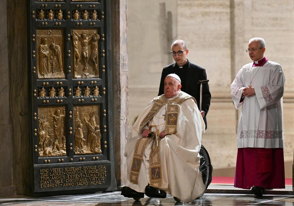 El Papa es ayudado a atravesar la Puerta Santa de la basílica de San Pedro, en el Vaticano