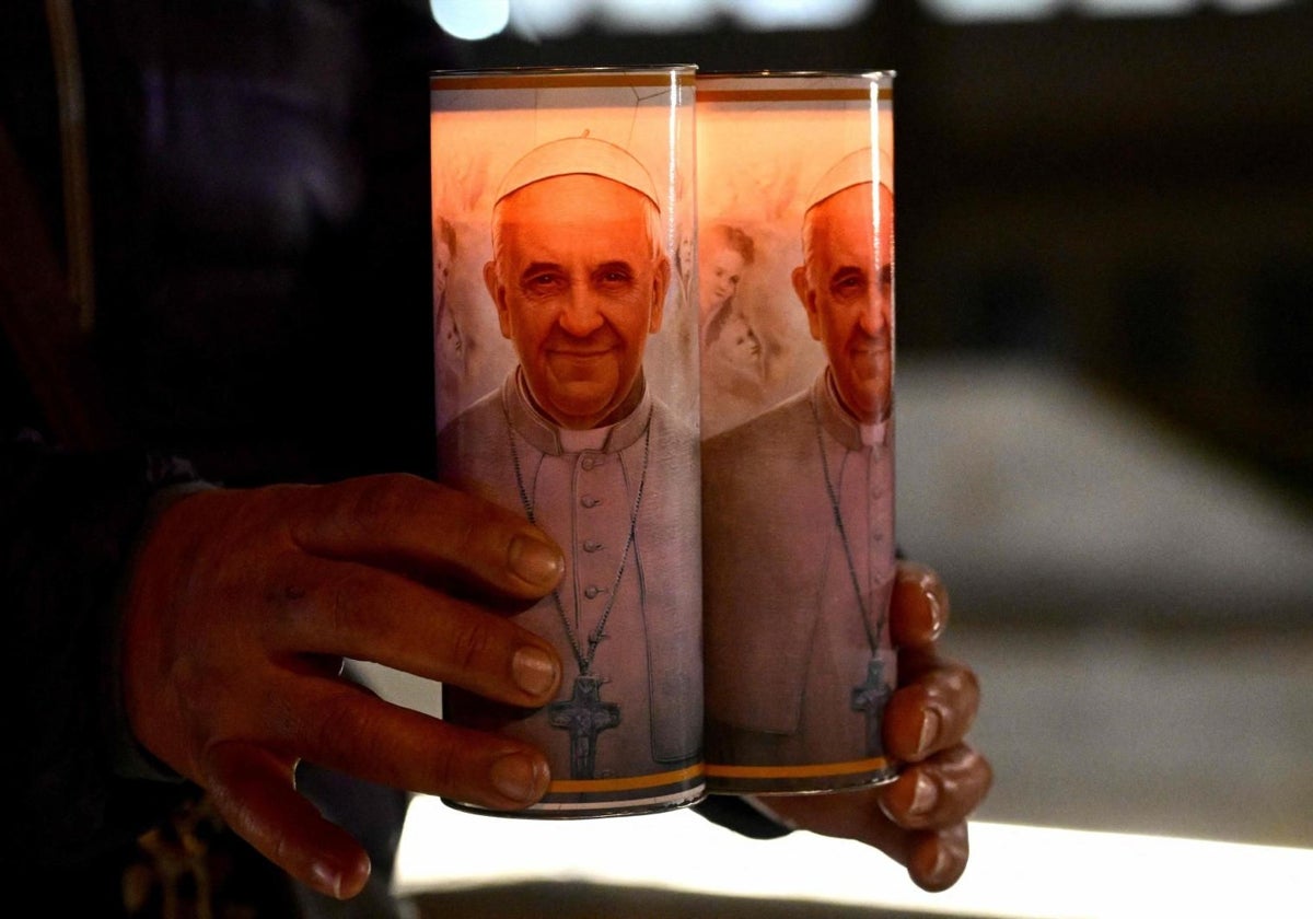 Los fieles rezan por la salud del Papa y llevan cirios frente a la puerta del hospital Gemelli