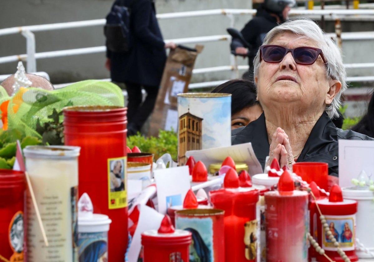 Una mujer reza por la curación del Papa Francisco frente al Hospital Gemelli