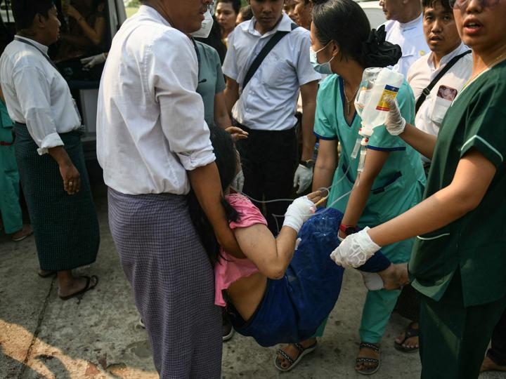 Trabajadores médicos transportan a un herido por el terremoto en el recinto de un hospital de Naypyidaw.