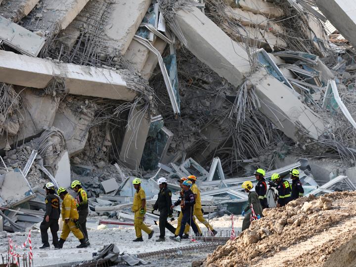 Personal de rescate camina cerca de un edificio que se derrumbó tras el fuerte terremoto que sacudió el centro de Myanmar.