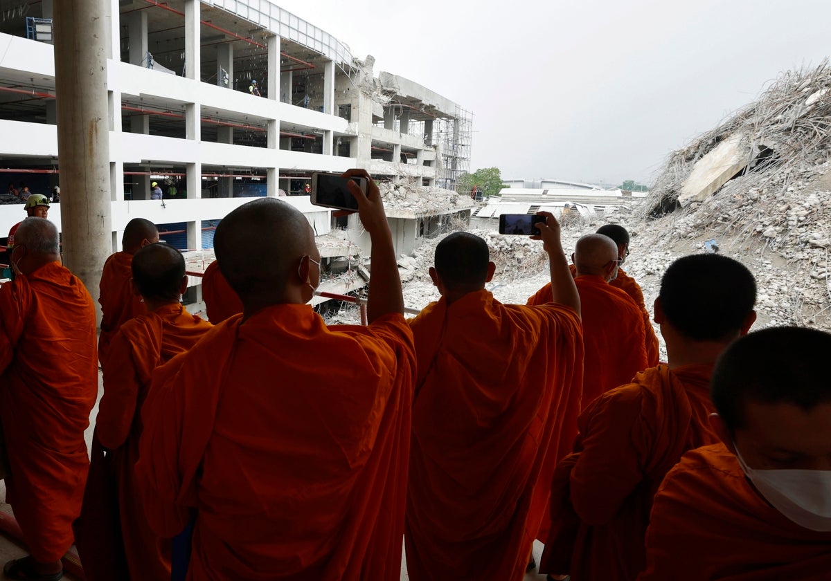 Varios monjes budistas fotografían en Bangkok los escombros que dejó el terremoto de hace dos semanas