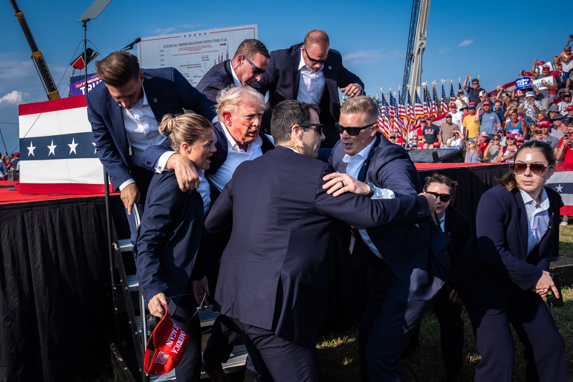 Miembros del Servicio Secreto de Estados Unidos ayudan al candidato presidencial republicano Donald Trump a bajar del escenario momentos después de que una bala le diera en la oreja durante un mitin de campaña en Pensilvania