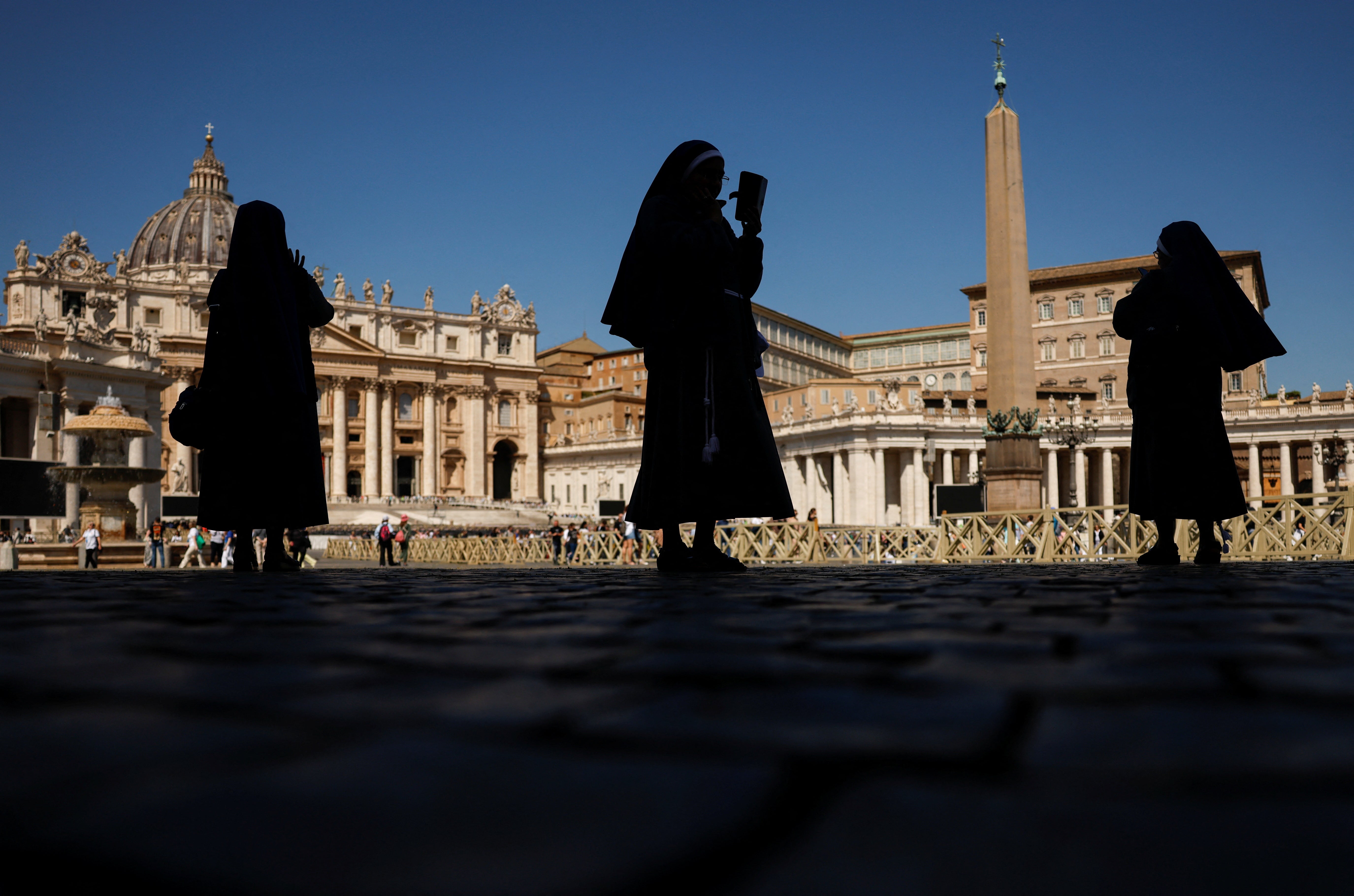 Varias monjas esperan en la Plaza de San Pedro.