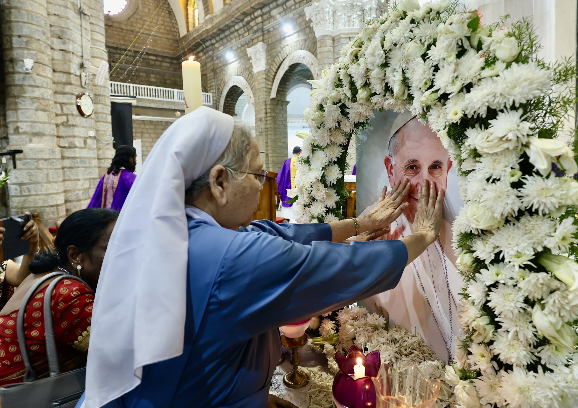 Una monja india reza ante la imagen del Papa en la catedral de Bangalore, India