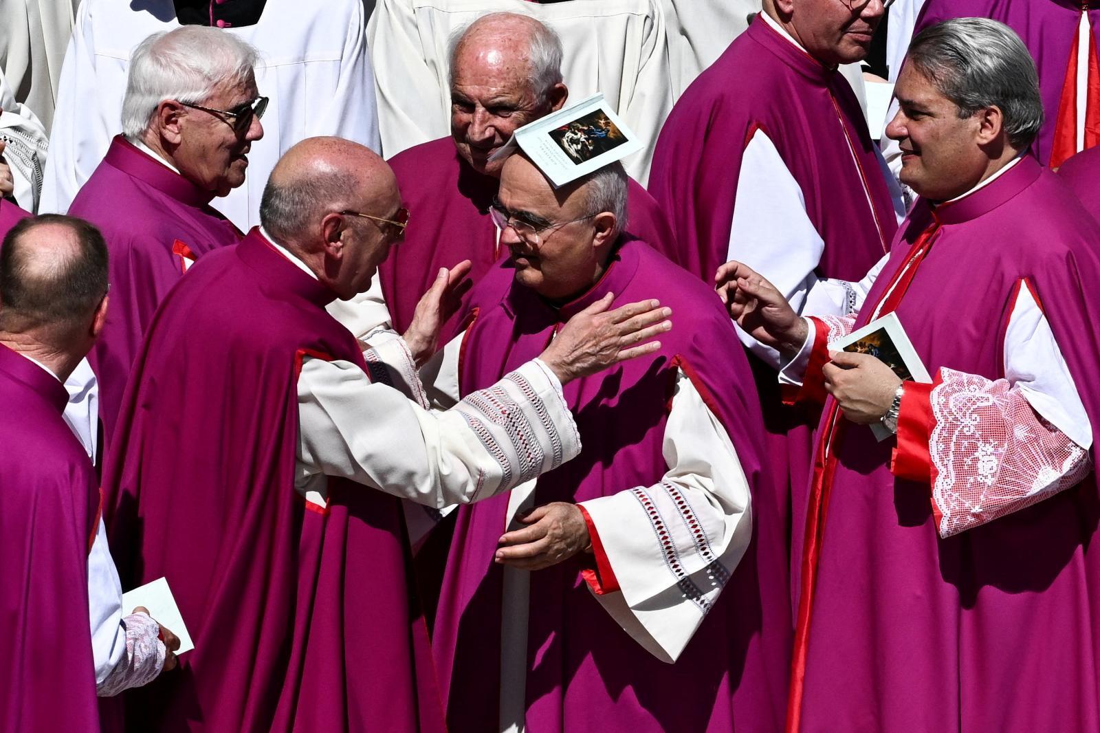 Ante el sol que reina en Roma, un miembro del clero improvisa un sombrero para protegerse