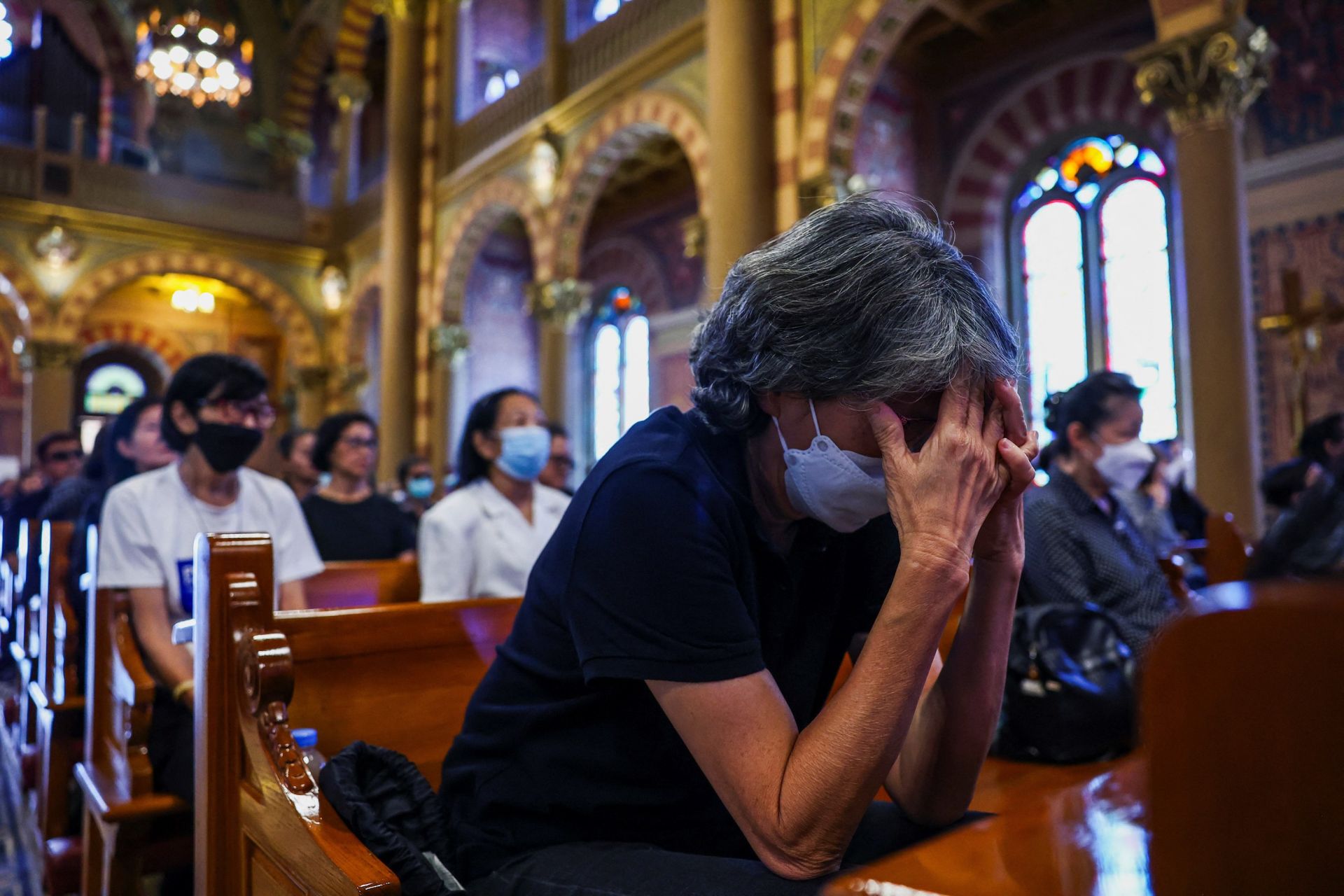 Una mujer se tapa la cara en la catedral de Bangkok