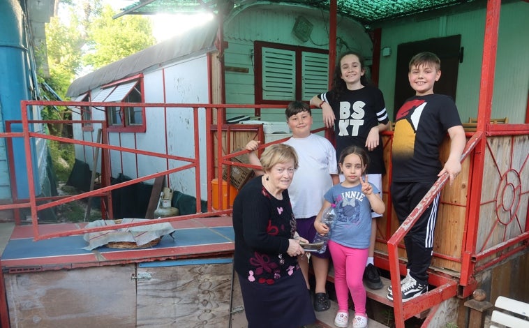 Imagen principal - Oscar posa con su abuela Epifania y otros niños que viven en el Lido. Epifania guarda como un tesoro las fotos de las visitas de Francisco. A la derecha, la calle del Papa Francisco 