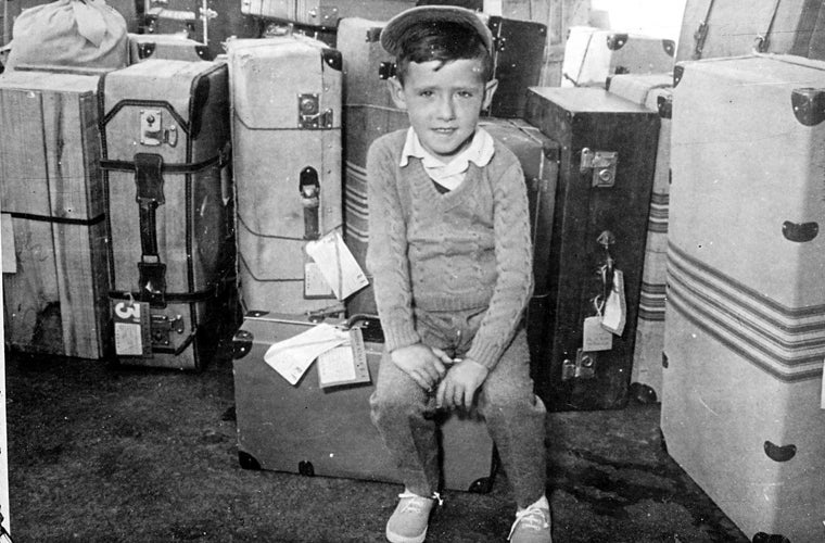 Niño sentado sobre una maleta en Madrid en los años 50