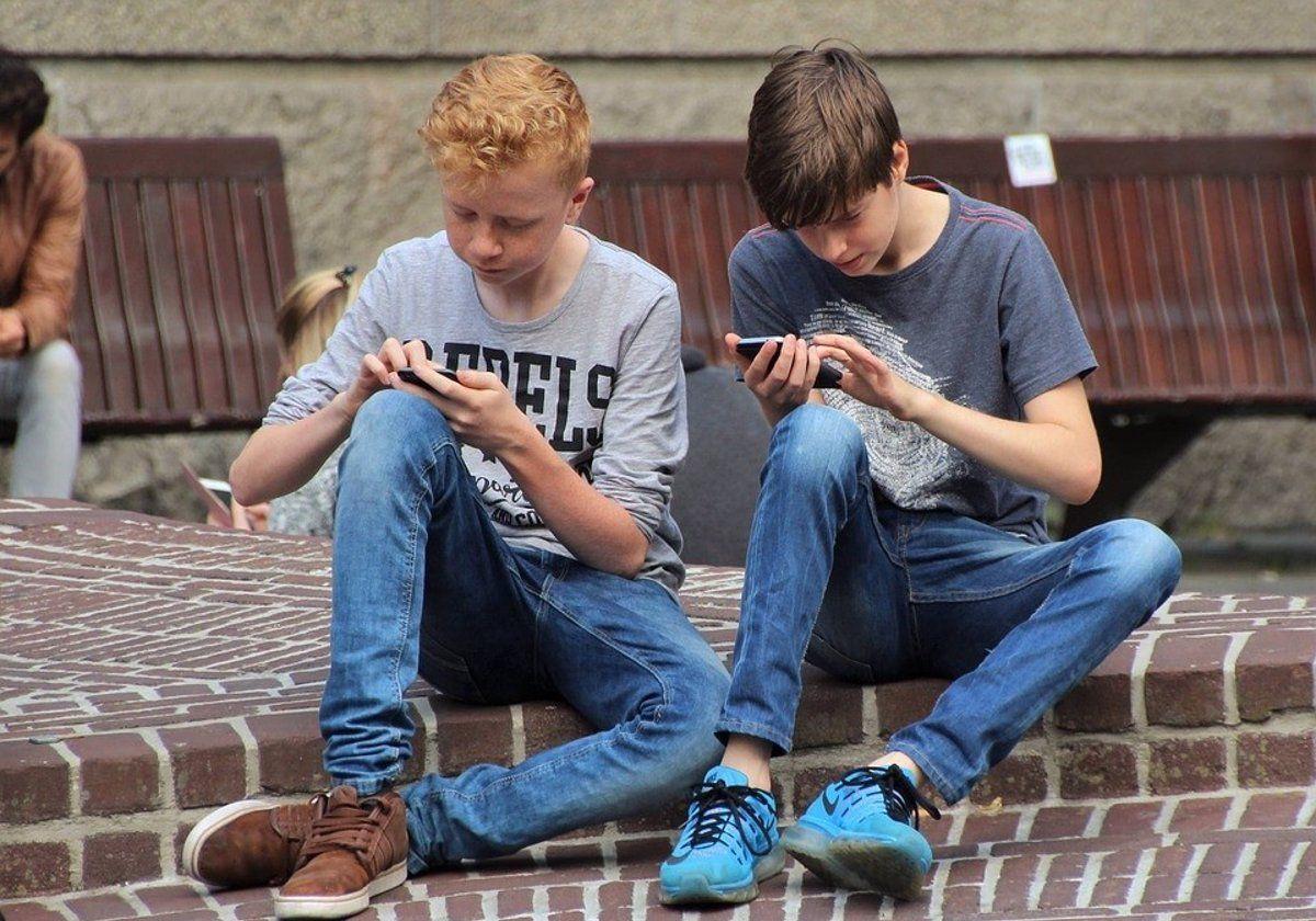 Dos jóvenes utilizan su teléfono móvil en una imagen de archivo