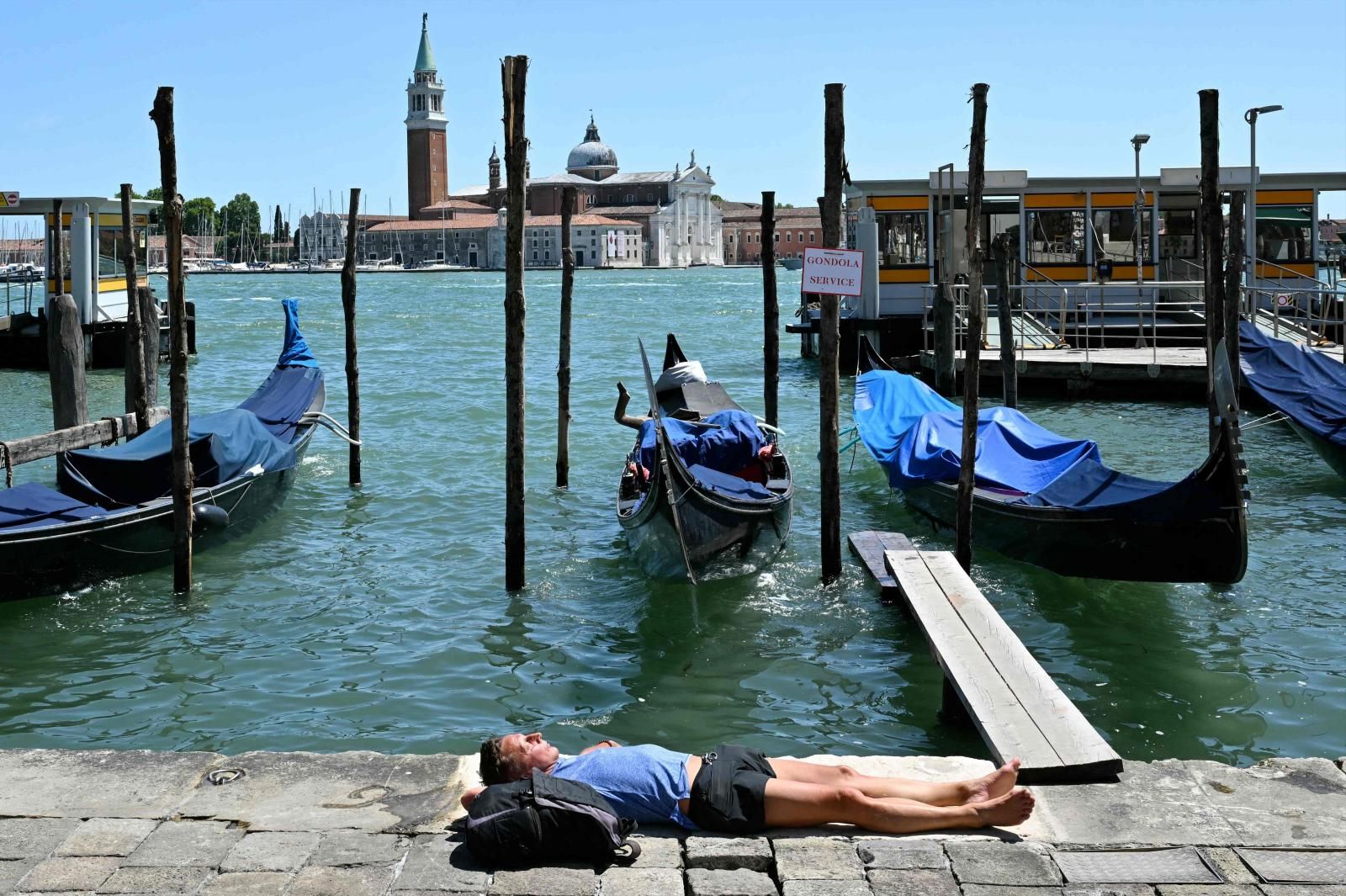 Un hombre se tumba al sol en Venecia durante la ola de calor.