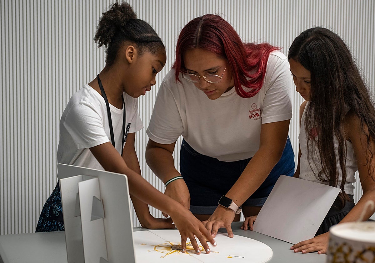 Micaela, con unos niños del programa CaixaProinfancia en un taller de ciencia en CaixaForum Sevilla