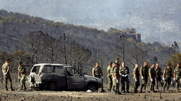 Un coche calcinado en el incendio forestal de Ribas de Saelices, cerca de Guadalajara, el 18 de julio de 2005.
