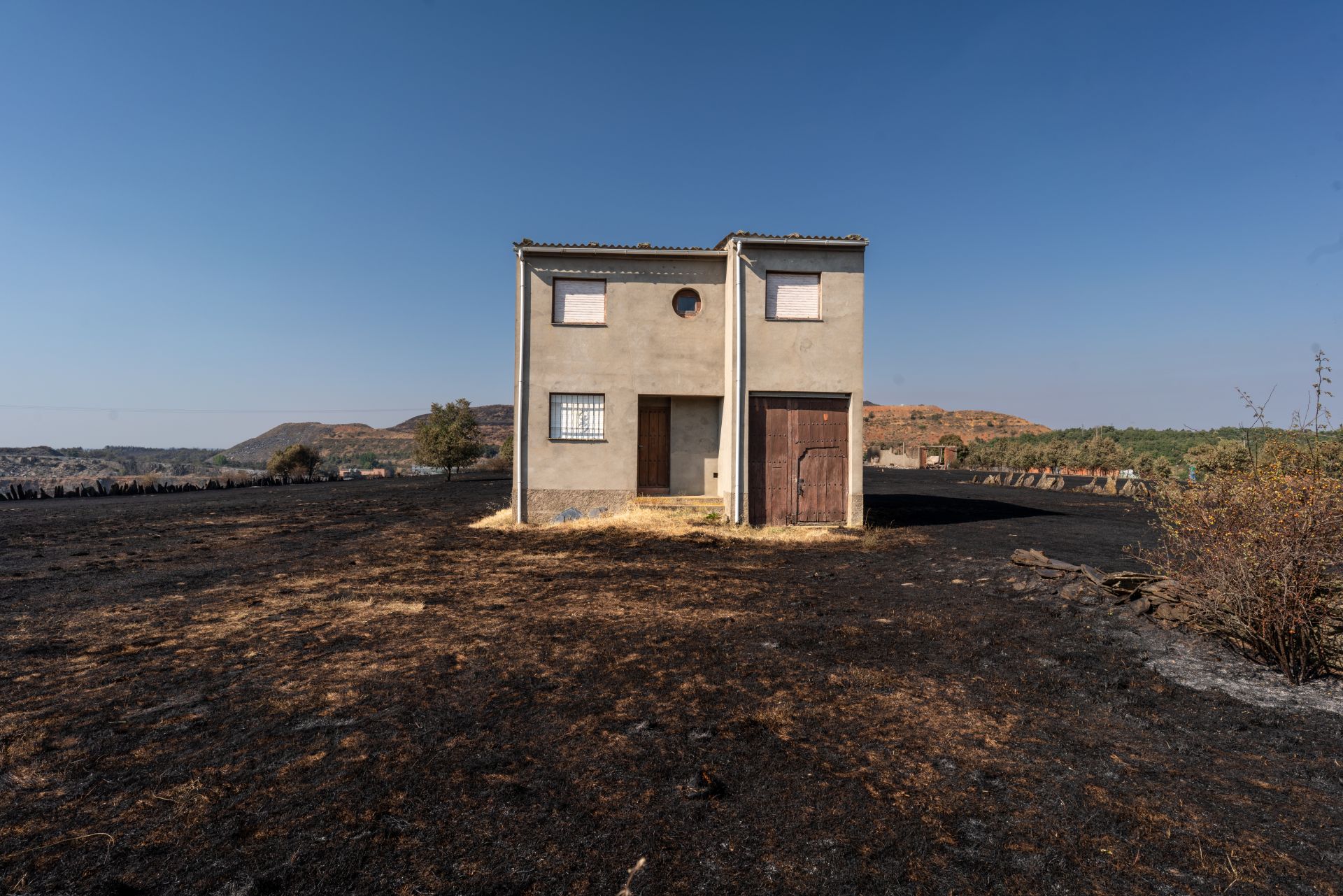 Una casa rodeada por un paisaje quemado como consecuencia del incendio de Puercas