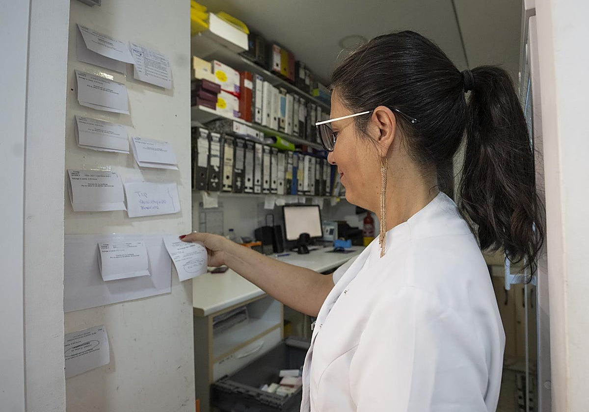 Una farmacéutica de una oficina de farmacia en Vallecas (Madrid) donde el papel aún es la mejor herramienta