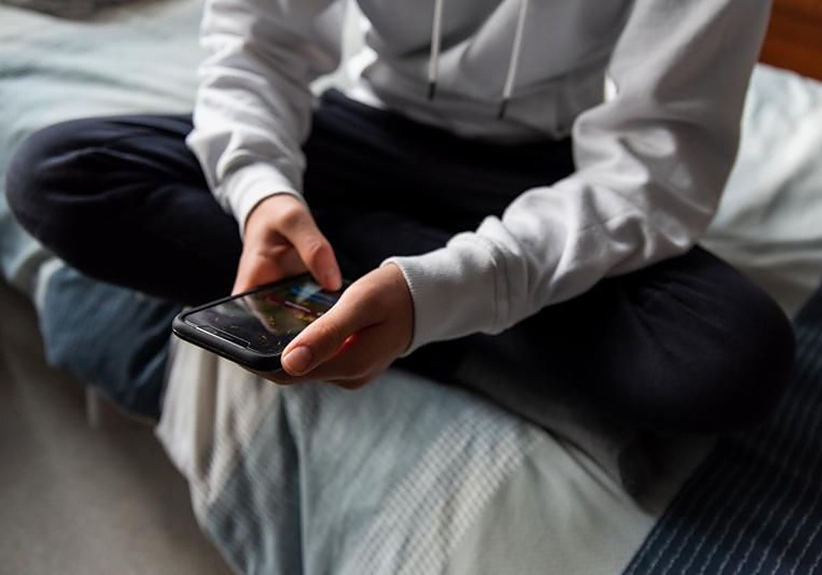 Un adolescente navega por internet con su teléfono móvil