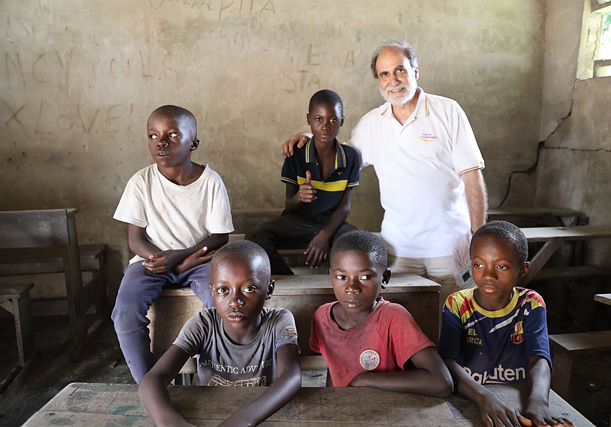 Enrique Barrio, presidente de Amigos de Monkole, con un grupo de chicos en una escuela