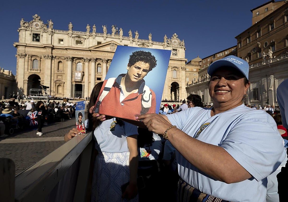 Una fiel sostiene una imagen del nuevo santo, Carlo Acutis, durante la ceremonia de canonización