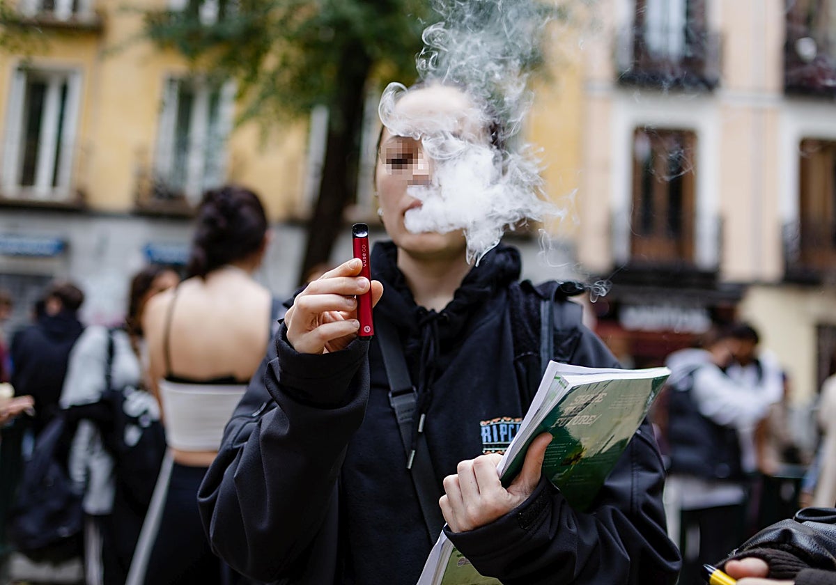 Una adolescente vapea a las afueras de un instituto en Madrid