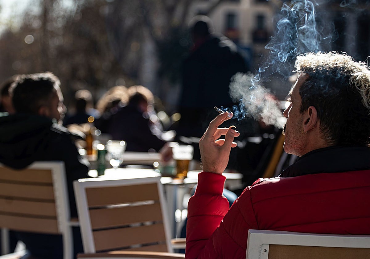 Un hombre fuma un cigarrillo en la terraza de un bar de Madrid