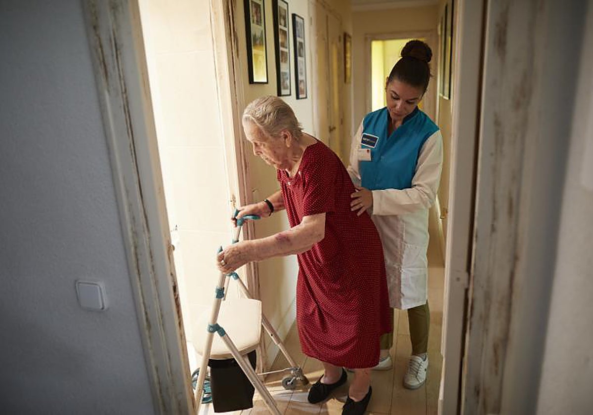 Herminia tiene 95 años y necesita ayuda para lo básico. Personal contratado por la Comunidad de Madrid la ayuda a lavarse y a hacer la cama