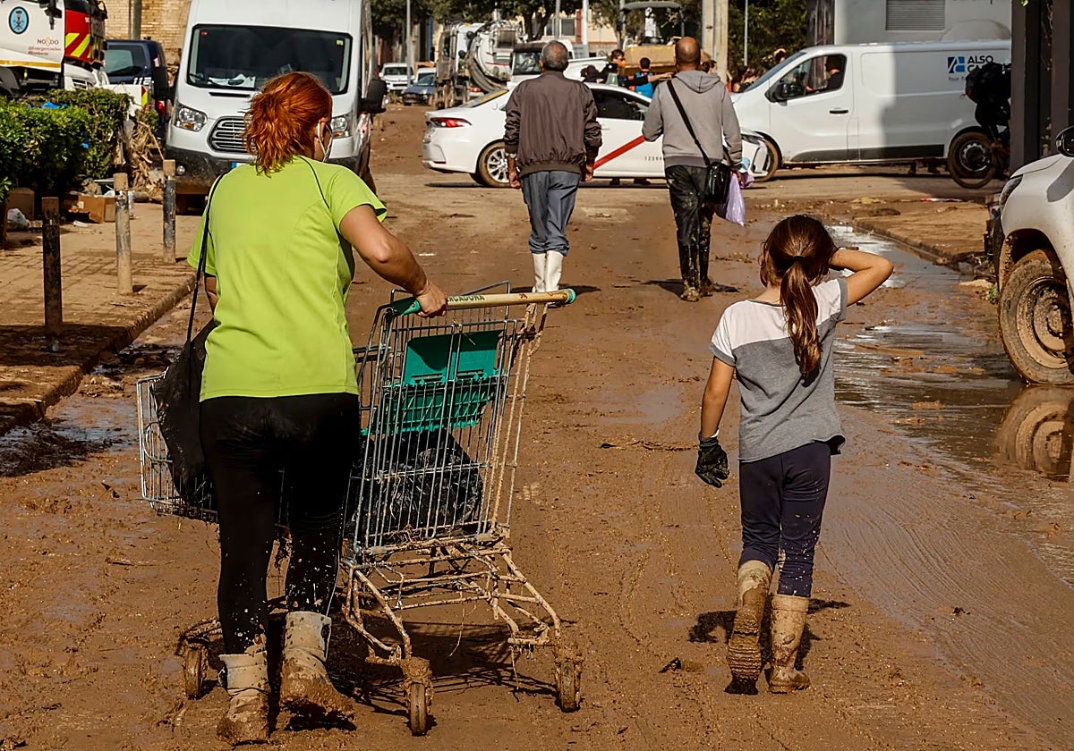 Una niña acompaña  a una adulta en las labores de retirada de escombros en Sedaví, Valencia, en una imagen de archivo