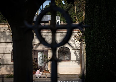 Imagen secundaria 1 - En la imagen superior, la entrada del cementerio este viernes, preparada para las visitas de los fieles difuntos de este fin de semana. Debajo, la casa en la que viven vista desde la valla exterior del cementerio. En la última foto, Marc con una bicicleta sigue a su hermano mayor, en un coche, en uno de sus juegos en el patio del cementerio 