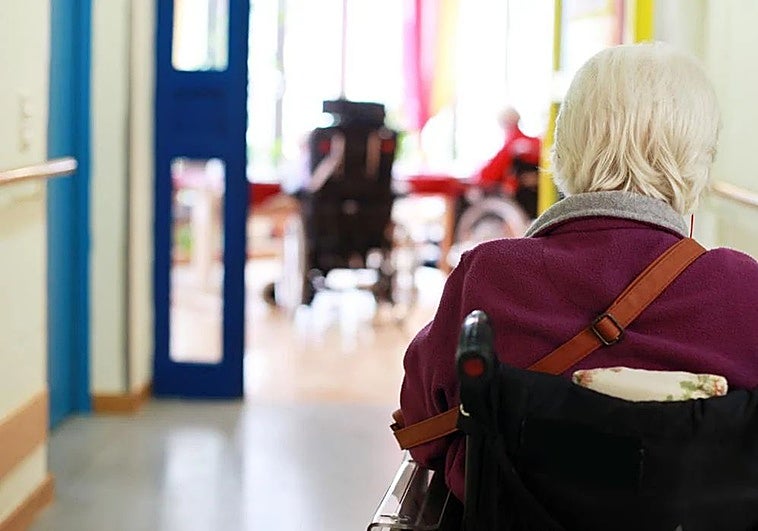 Una mujer en silla de ruedas en una residencia de mayores.