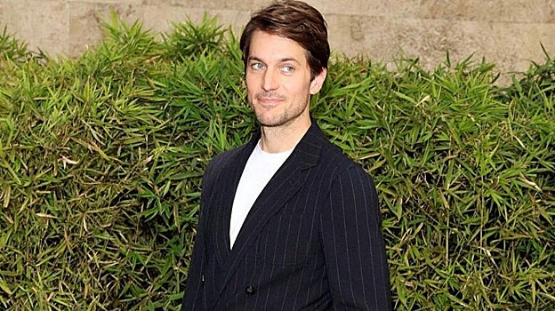 Lucas Bravo con traje de raya diplomática