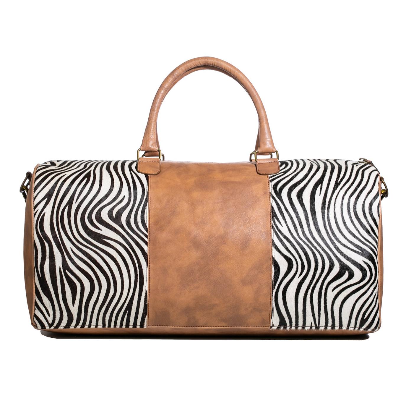 Bolsa de viaje Mimisicu (485 €). De piel de vacuno en color negro y forro interior de algodón orgánico. Con correa larga para llevar cruzada y bolsillo en la parte trasera. Patchwork, piel de pelo y piel de vacuno.