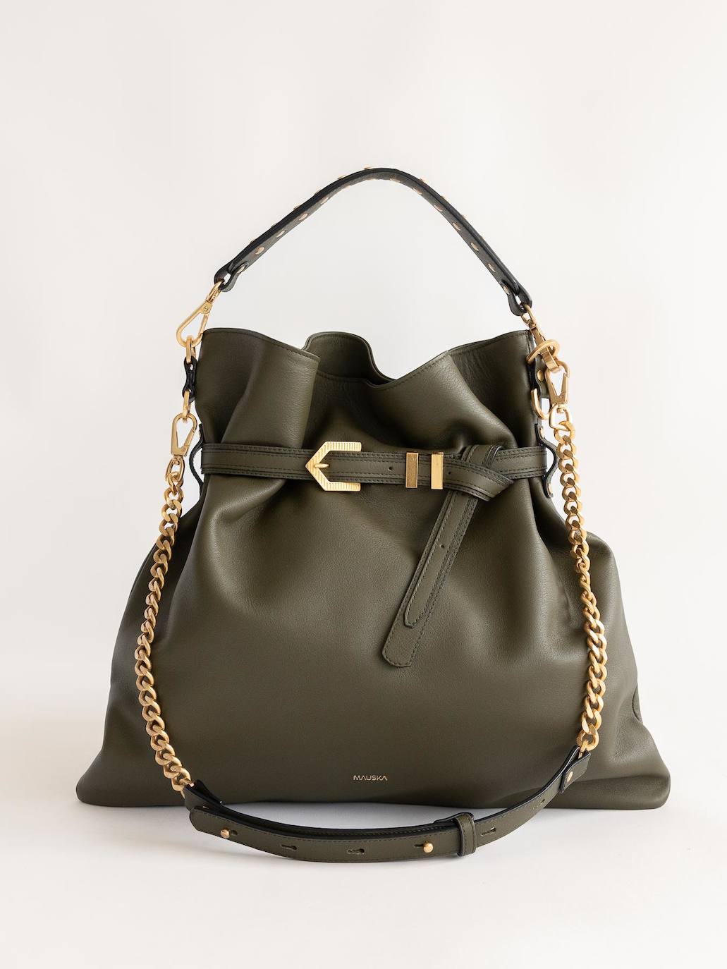 Bolso Pereira maxi caqui oscuro de Mauska (345 €). Bolso hobo manufacturado con una refinada piel excepcional. La cadena de latón y las tachuelas bañadas en oro de 24 kilates le dan un toque elegante. Se cierra mediante una correa exterior ajustable. Hecho a mano en Ubrique, por artesanos y usando piel de becerro de la más alta calidad.