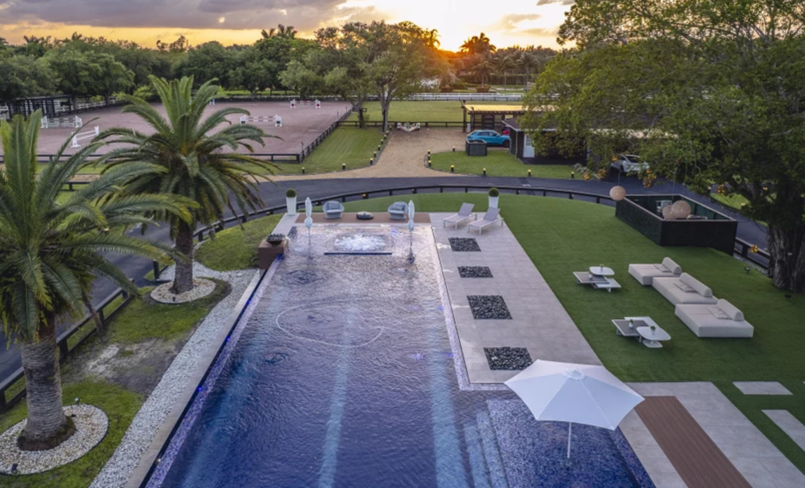 La zona exterior incluye una piscina con borde infinito, solárium y varias instalaciones deportivas