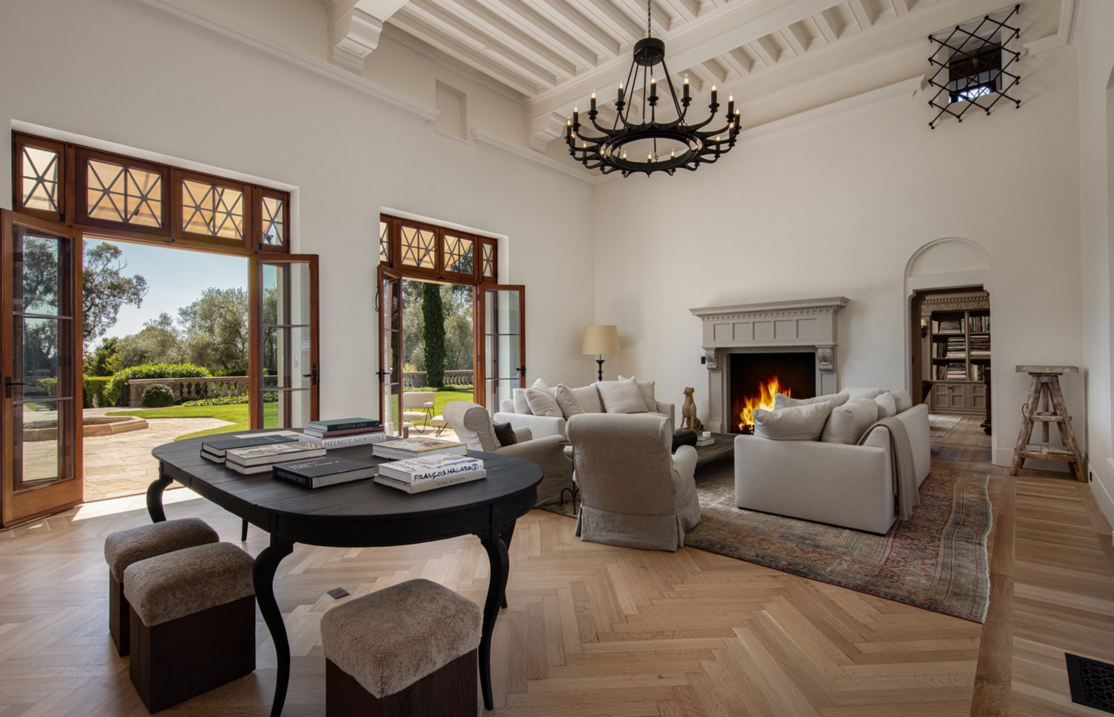 La sala de estar principal cuenta con chimenea y destaca por sus altos techos con vigas de madera vistas y sus suelos de madera