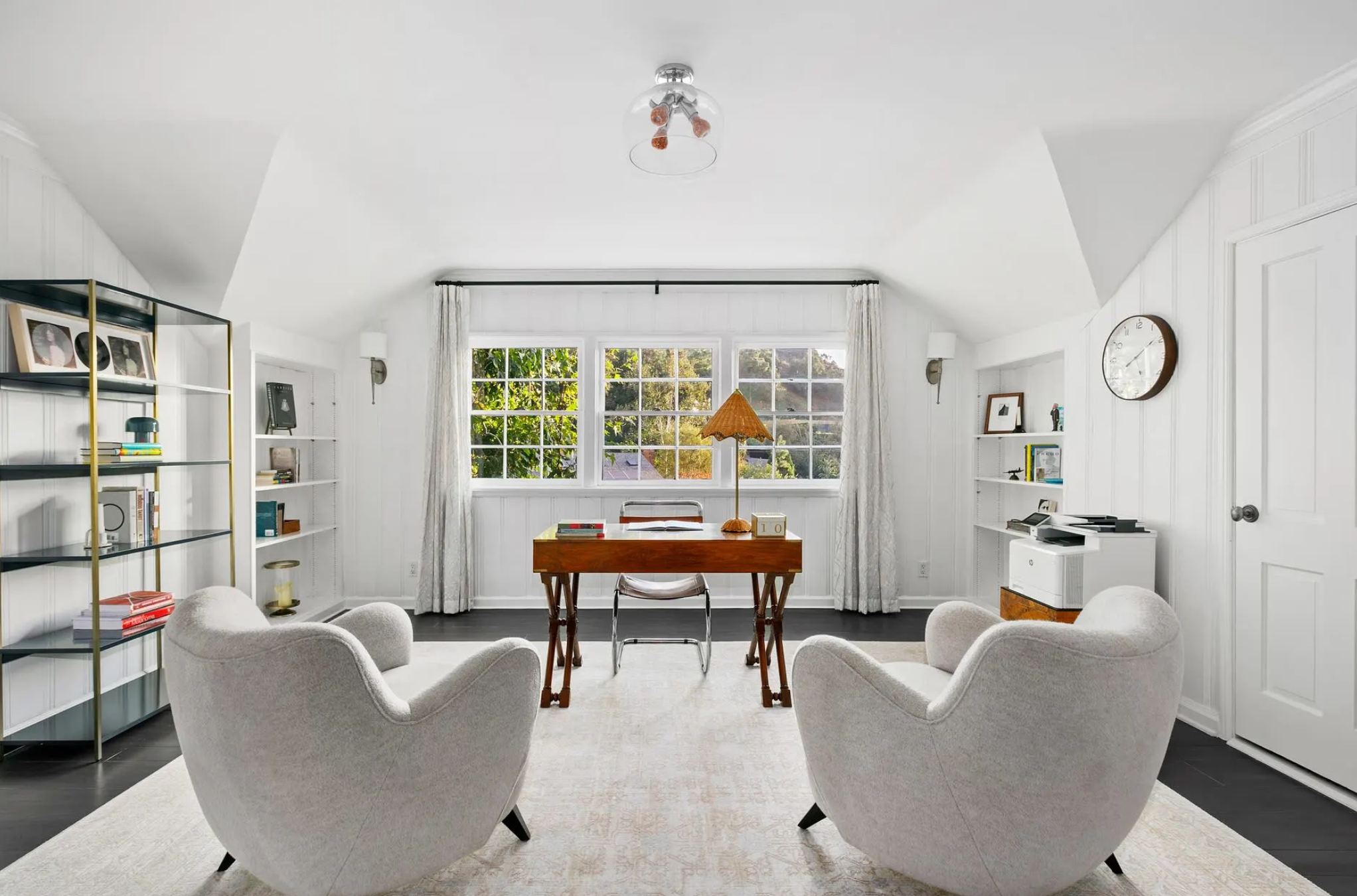 En la planta superior hay una oficina con grandes ventanales que inundan de luz natural el espacio 