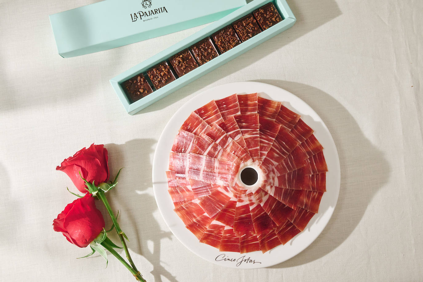 Regalar chocolate siempre es un placer y, combinado con jamón de bellota 100% ibérico, es una revolución para los sentidos. En un día tan especial, Cinco Jotas y La Pajarita se alían para lanzar un regalo de edición limitada. Una obra de arte, elaborada de forma tradicional por los maestros chocolateros de La Pajarita con mucho mimo con chocolate equilibrado entre tostado, amargo y 74% cacao y jamón Cinco Jotas deshidratado que aportará un sabor umami sin igual. El pack de edición limitada estará a la venta en la web de La Pajarita y en sus puntos de venta físicos de Madrid: Calle Villanueva 14, Galería Canalejas y Las Rozas Village a partir del 1 de febrero. Precio: 41,90 euros.