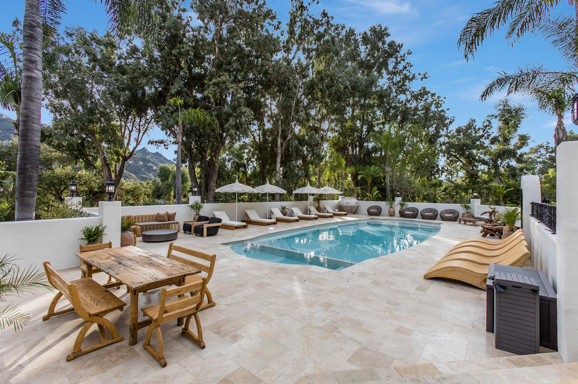 La zona exterior incluye una piscina, solárium y una construcción independiente que funciona como gimnasio