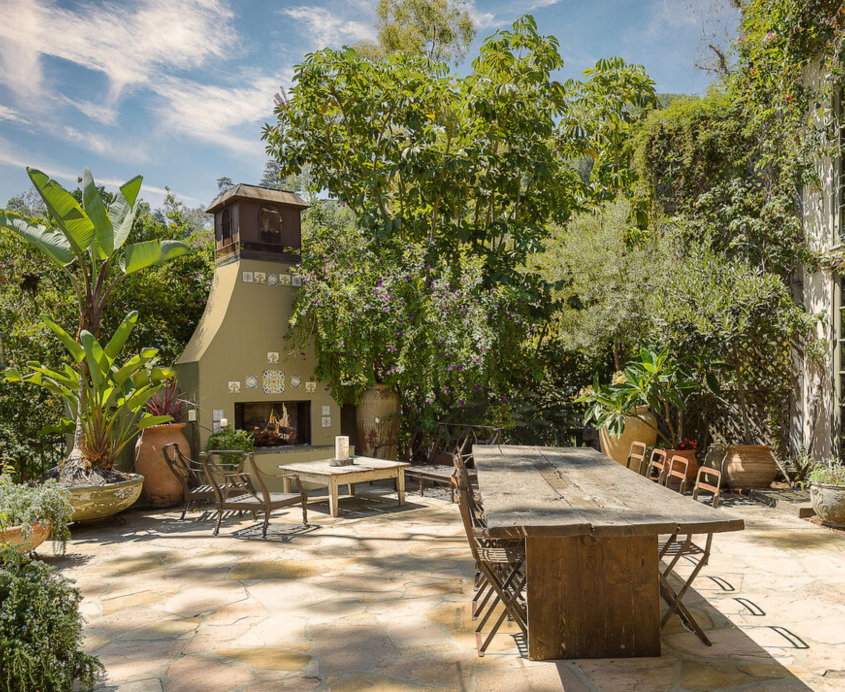 La zona exterior incluye un comedor al aire libre con chimenea y una gran mesa con capacidad para diez comensales, varias zonas de relax y un patio repleto de vegetación 