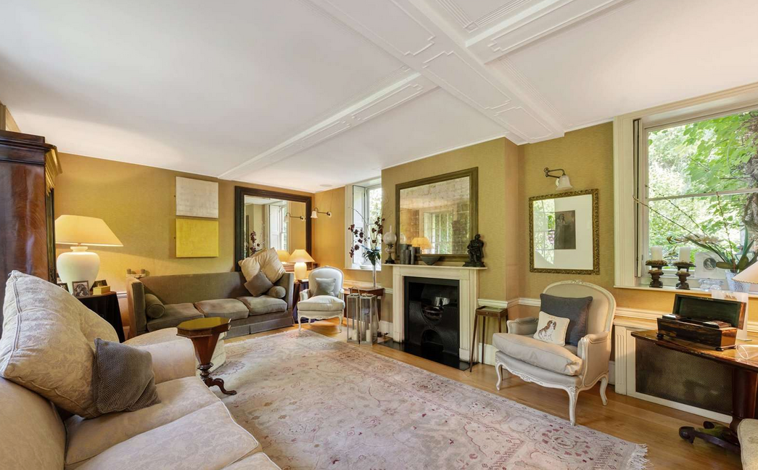 Imagem principal - Uma das salas de estar com lareira, o quarto principal e a sala de jantar