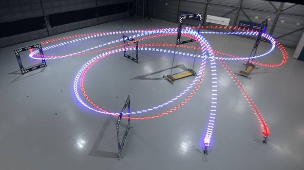 La estela azul marca la ruta del dron movido por IA, la roja, la del humano