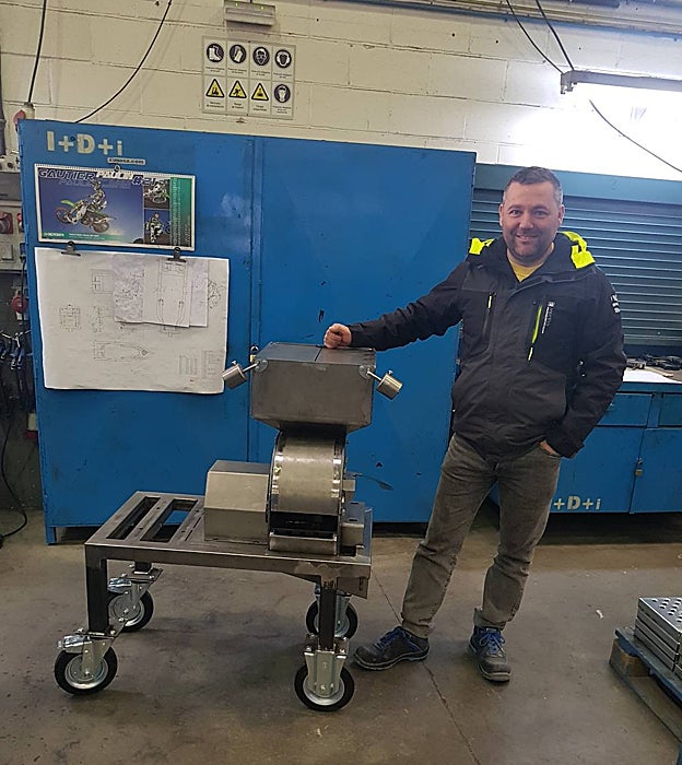 Santiago López junto a su trituradora de escombros