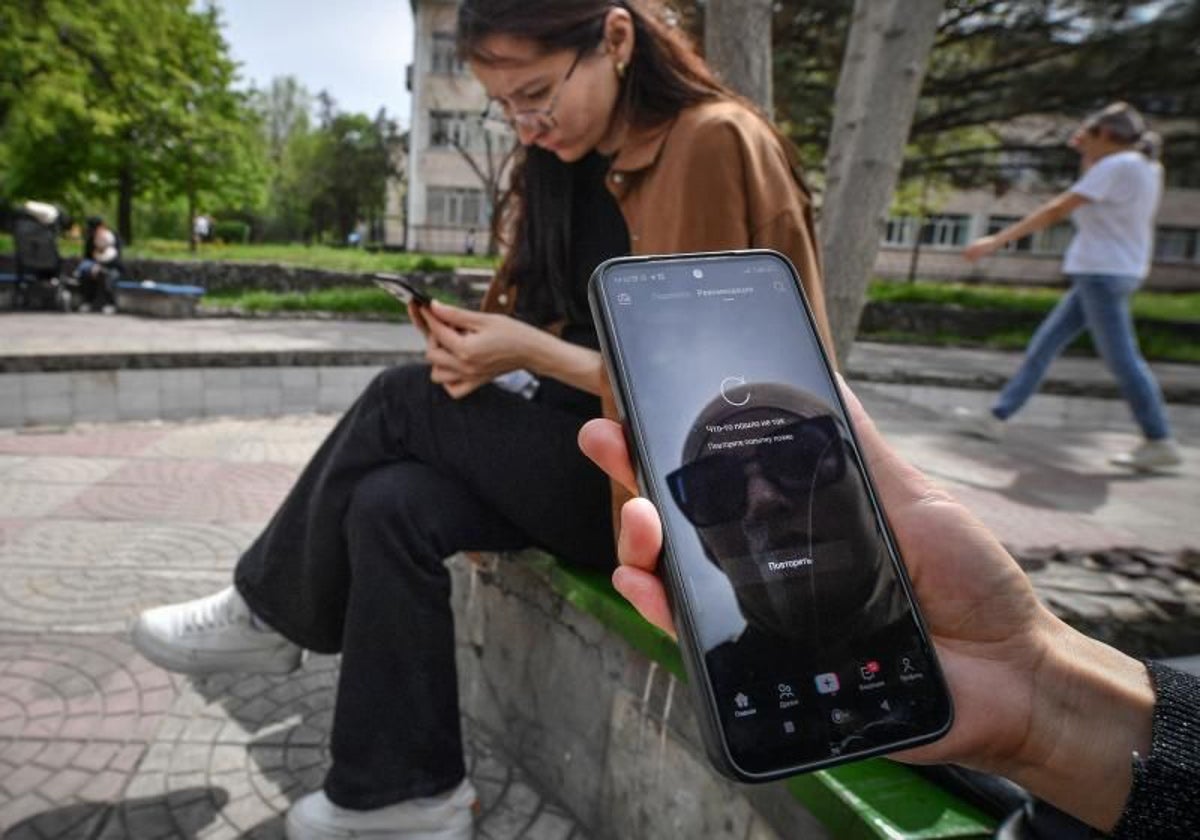 Dos mujeres utilizan sus teléfonos móviles en una ciudad europea