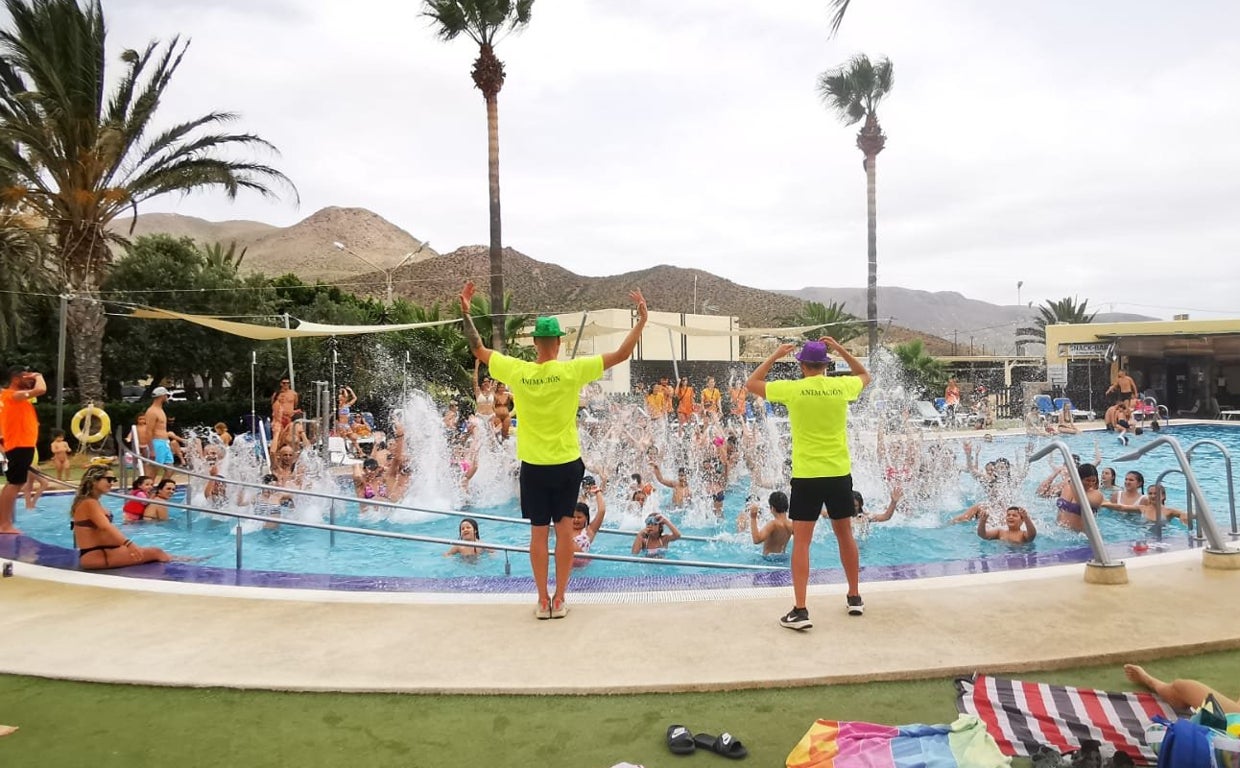 Dos animadores durante una actividad en la piscina del camping Los Escullos en Níjar.