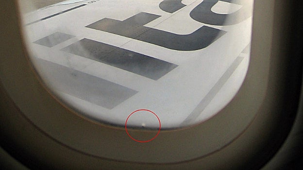 Una ventanilla de un avión con su correspondiente agujero en la parte inferior