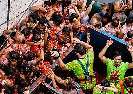 Imagen secundaria 1 - Los participantes en la Tomatina, cada 31 de agosto, lanzan a la calle, unos contra otros, unos 130.000 kilos de tomates que vuelan y se estampan como un curioso y espectacular símbolo de alegría.