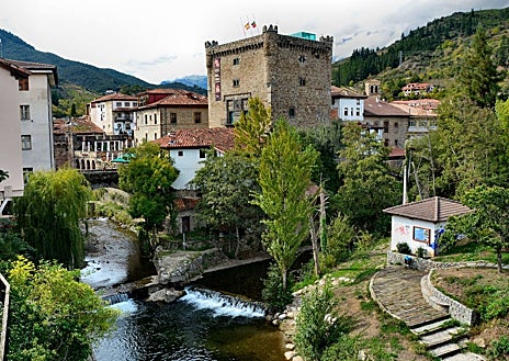 Imagen secundaria 1 - Arriba, el Puente de San Cayetano, en Potes (Cantabria). Sobre estas líneas, a la derecha, Pedro Álvarez, cronista oficial de Liébana, en la Puerta del Perdón, en Santo Toribio de Liébana, a tres kilómetros del pueblo. A la izquierda, la Torre del Infantado, en Potes.