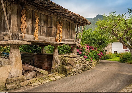 Imagen secundaria 1 - lLa Cuevona es una de las contadas cavidades naturales del mundo cruzada de extremo a extremo por una carretera asfaltada -decididamente angosta en este caso-, que va a morir entre las casas de Cuevas del Agua. Sobre estas líneas, a la izquierda, una panera, antigua edificación rural sobre pilares para almacenar el cereal.