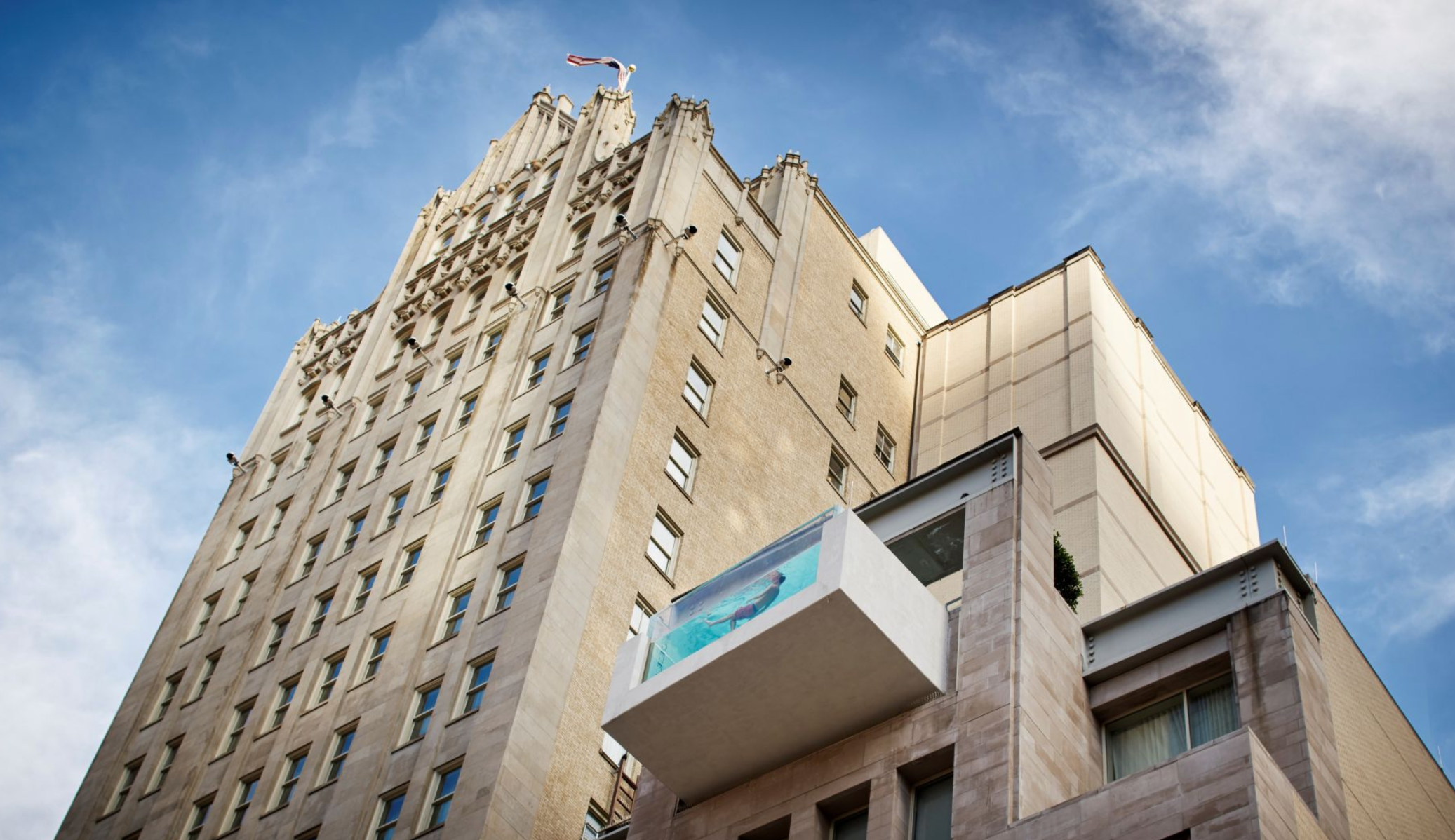 Situado en un emblemático edificio neogótico de los años 20, en el corazón del distrito central de negocios de Dallas (Texas), está el hotel boutique The Joule. El alojamiento, que expone en sus espacios comunes la colección de arte de su propietario Tim Headington, dispone de 160 habitaciones, suites y penthouses equipados con todas las comodidades, dos restaurantes de primer nivel, gimnasio y un spa subterráneo con un enfoque holístico del bienestar. Por su parte, la piscina de este hotel resulta espectacular y no porque esté rodeada de naturaleza, ni ofrezca vistas al mar, sino porque parte de ella está suspendida más allá de la fachada del edificio y cuenta con una pared de vidrio que permite a los más valientes asomarse a la ciudad.