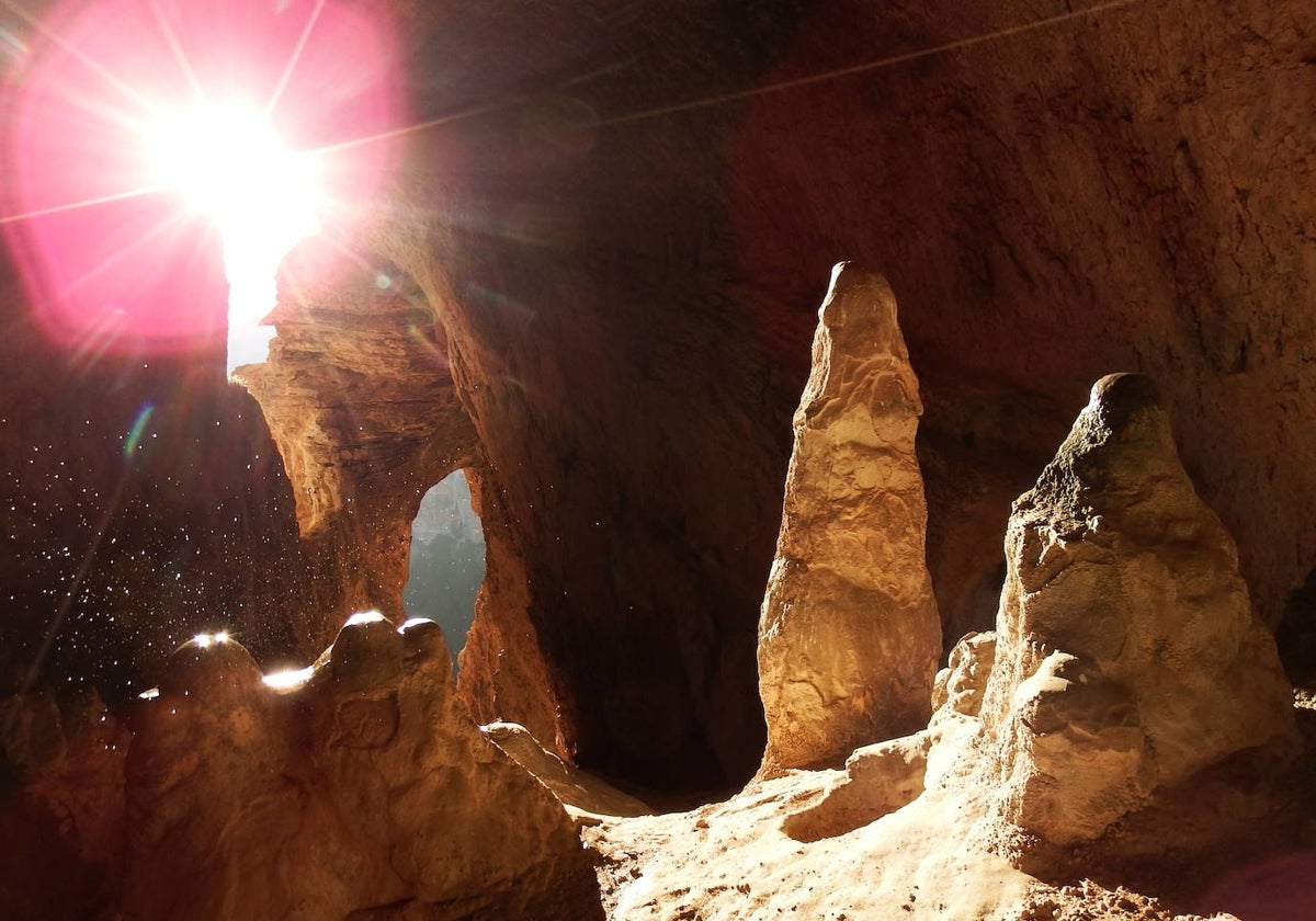 La luz llega a una cueva e ilumina una estalagmita en el Santuario solar del río Vero